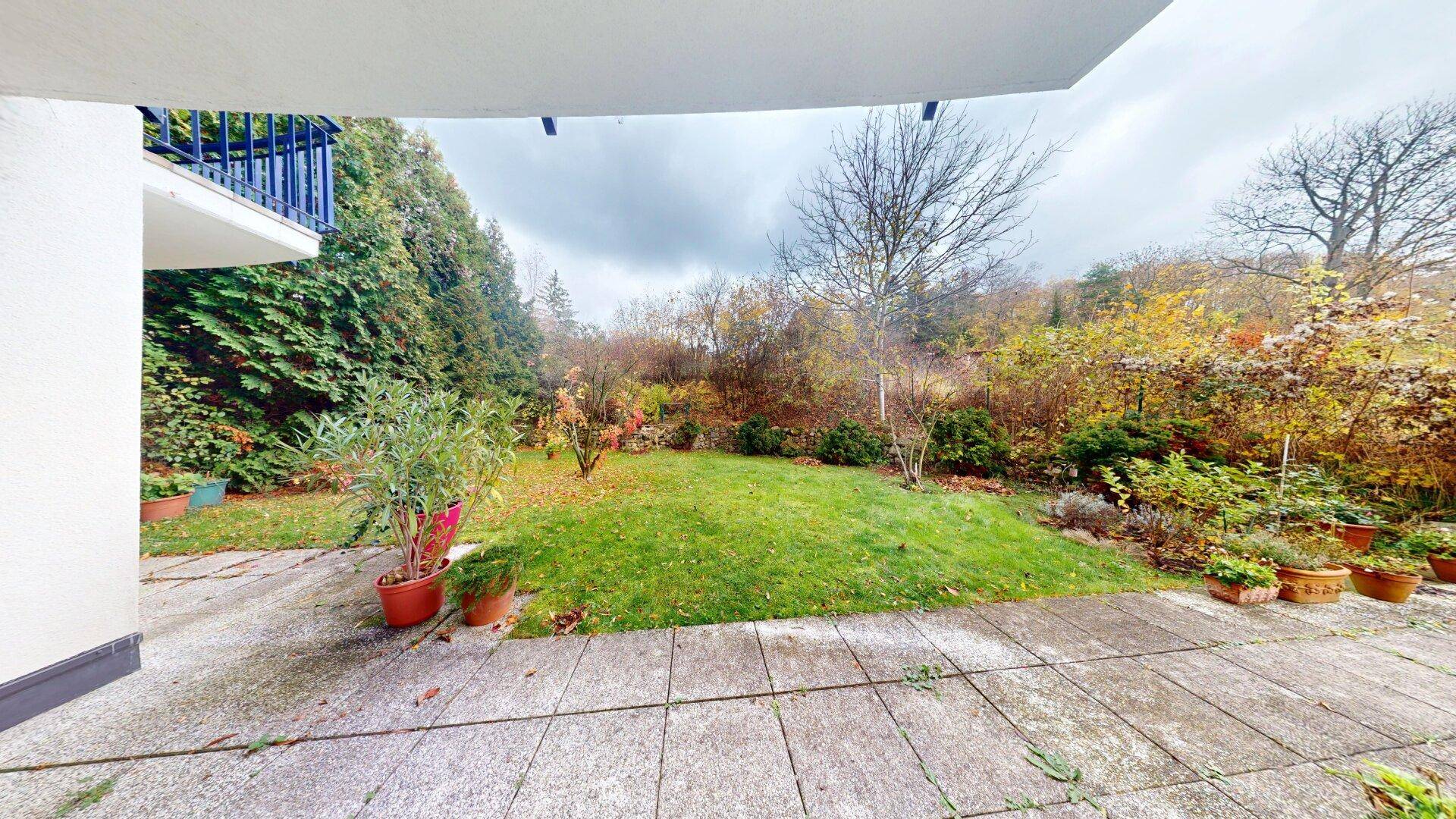 Geräumige Steinterrasse mit Blick auf den Garten und die umliegende Natur.