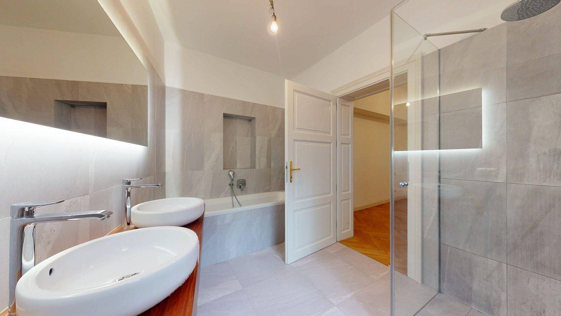 Helles Badezimmer mit begehbarer Dusche, Badewanne und modernen Doppelwaschbecken.