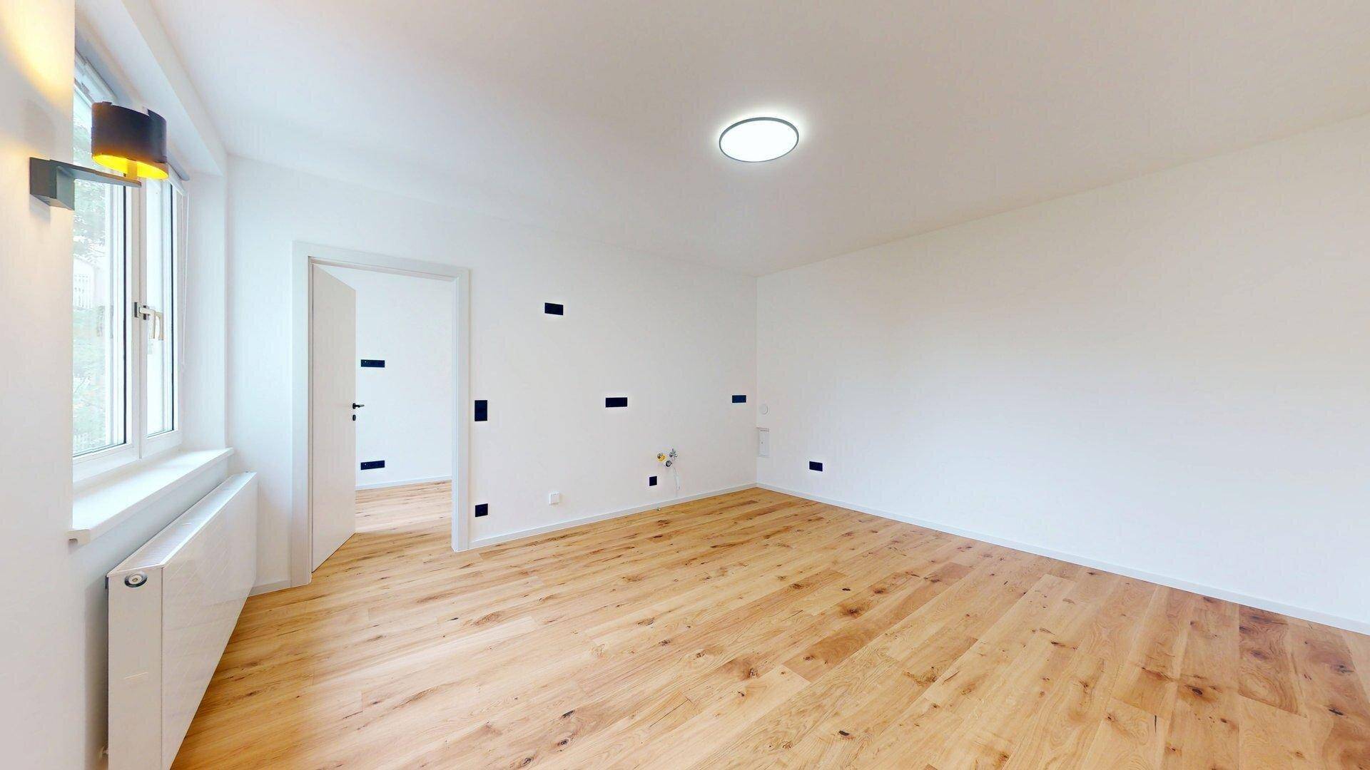 Geräumiges Zimmer mit hellem Holzboden und viel Tageslicht, bereit zur individuellen Gestaltung.