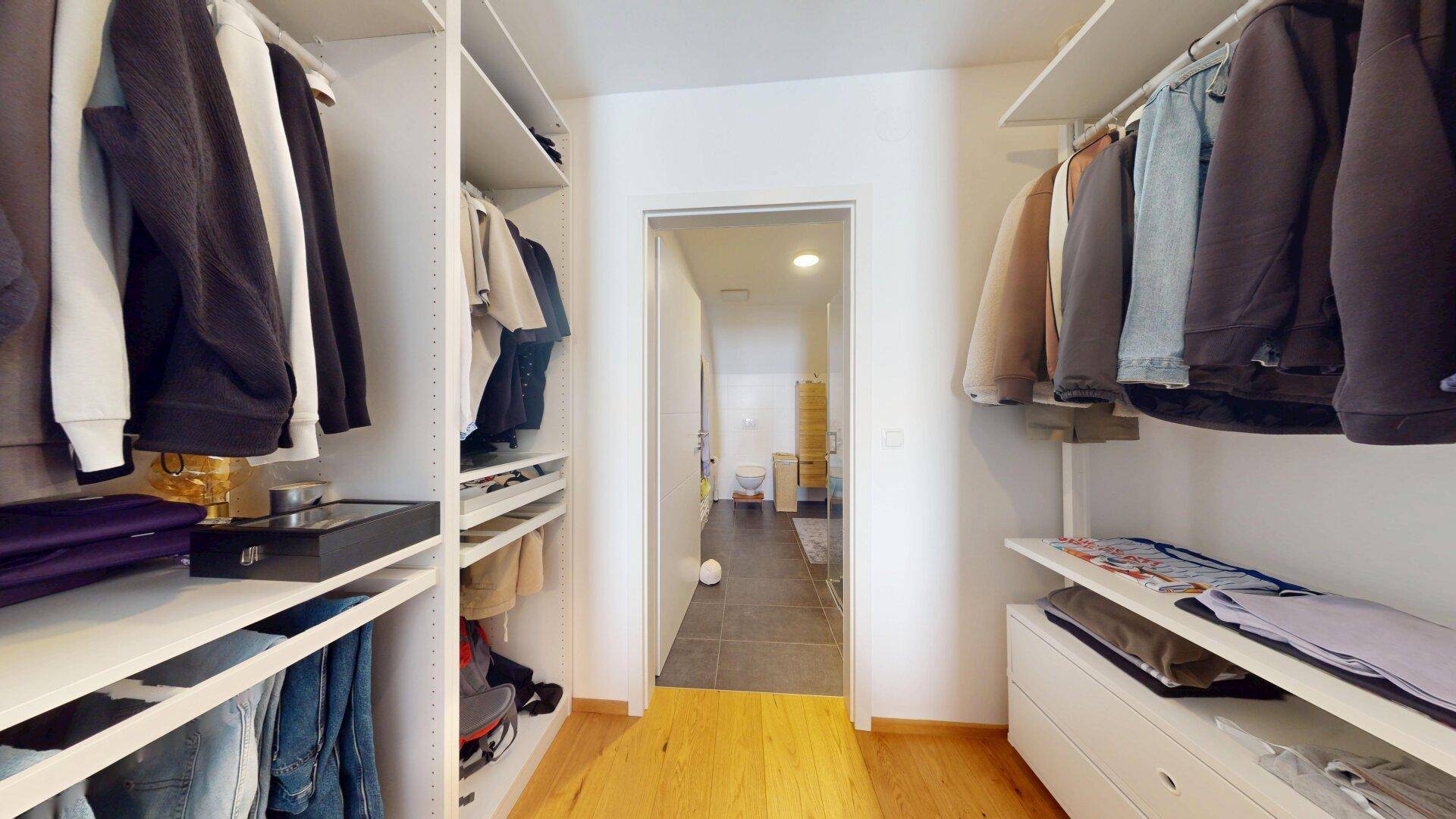 Geräumiger begehbarer Kleiderschrank mit Regalen und Hängestangen.