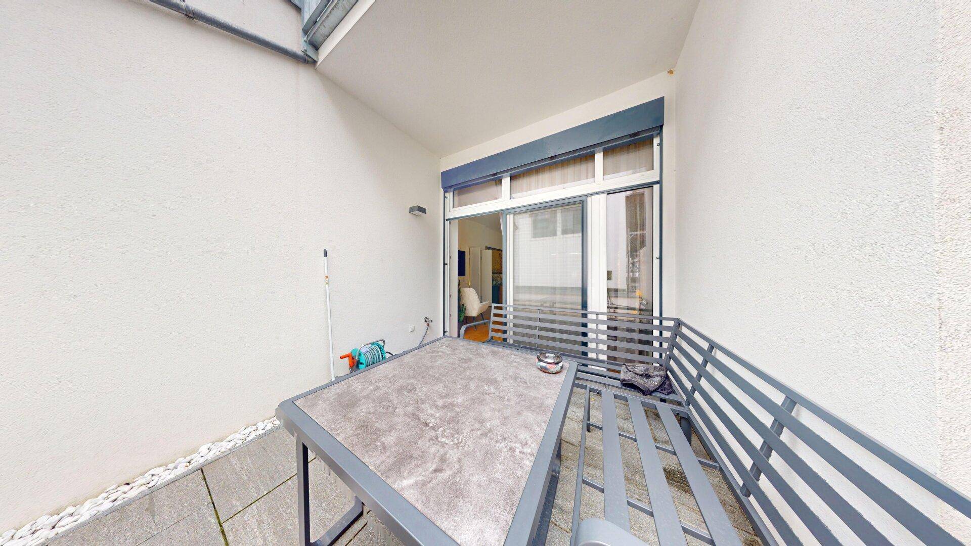 Überdachte Terrasse mit Sitzbank und Tisch, ideal für entspannte Stunden im Freien.