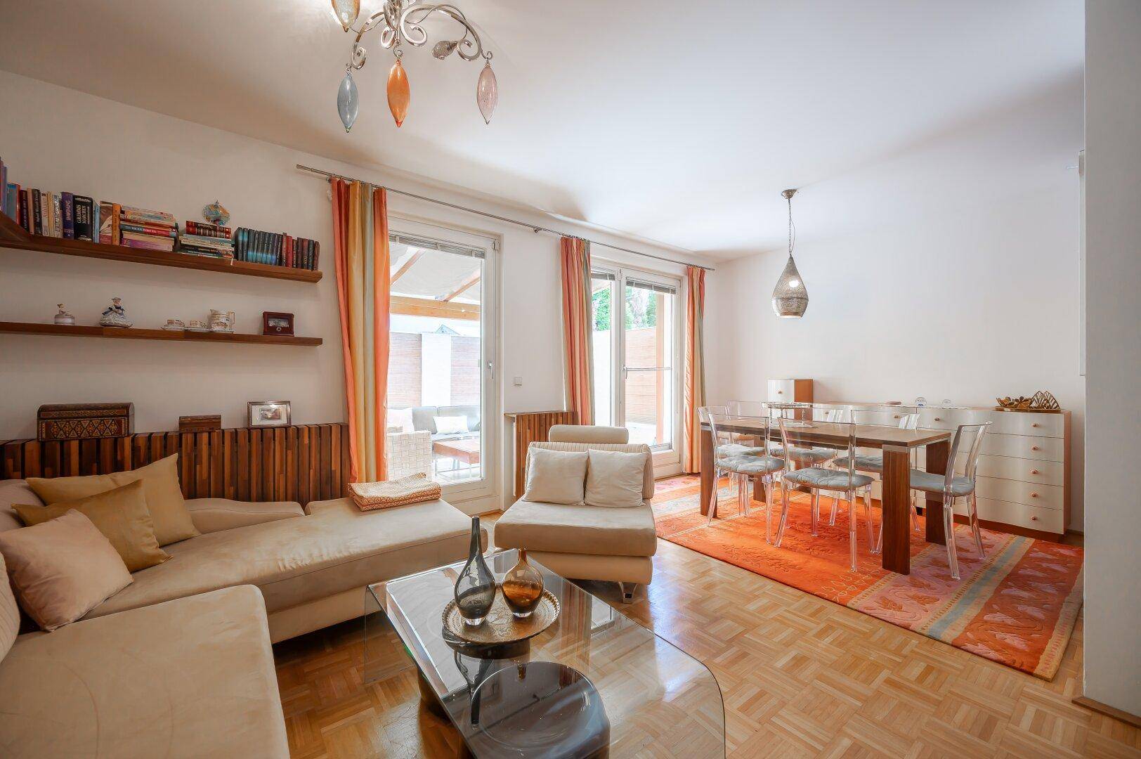 Heller Wohn-Essbereich mit Parkettboden, gemütlichem Sofa und Zugang zur Terrasse.
