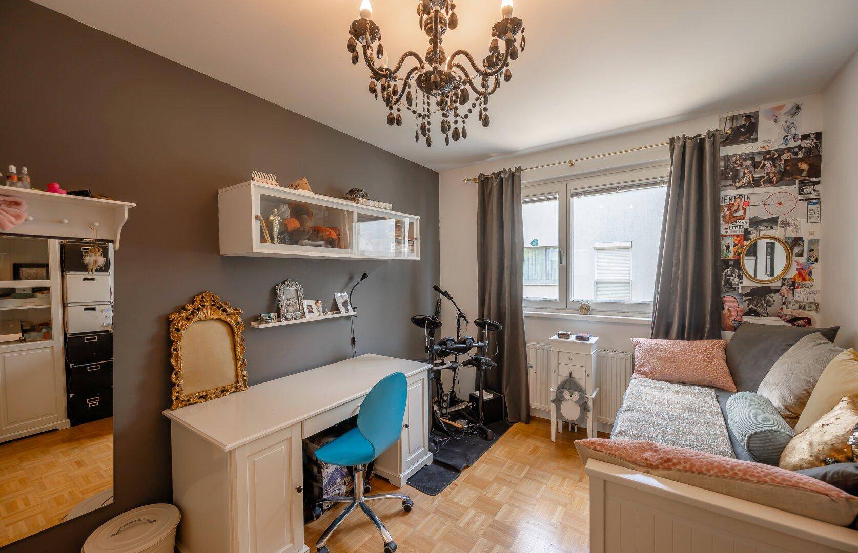 Jugendzimmer oder Gästezimmer mit Schreibtisch, Tagesbett und dunkler Akzentwand.
