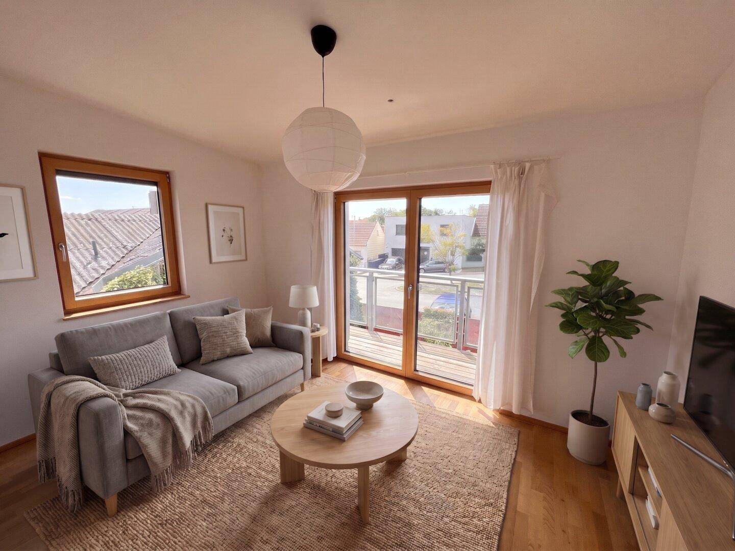 Gemütliches Wohnzimmer mit Sofa, Couchtisch und Zugang zu einem Balkon, hell und modern.