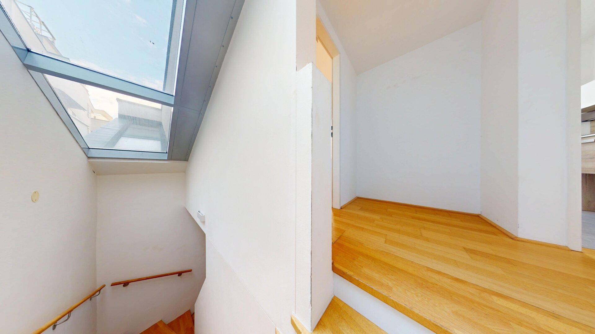 Treppenhaus mit großem Oberlicht, das viel natürliches Licht hereinlässt.