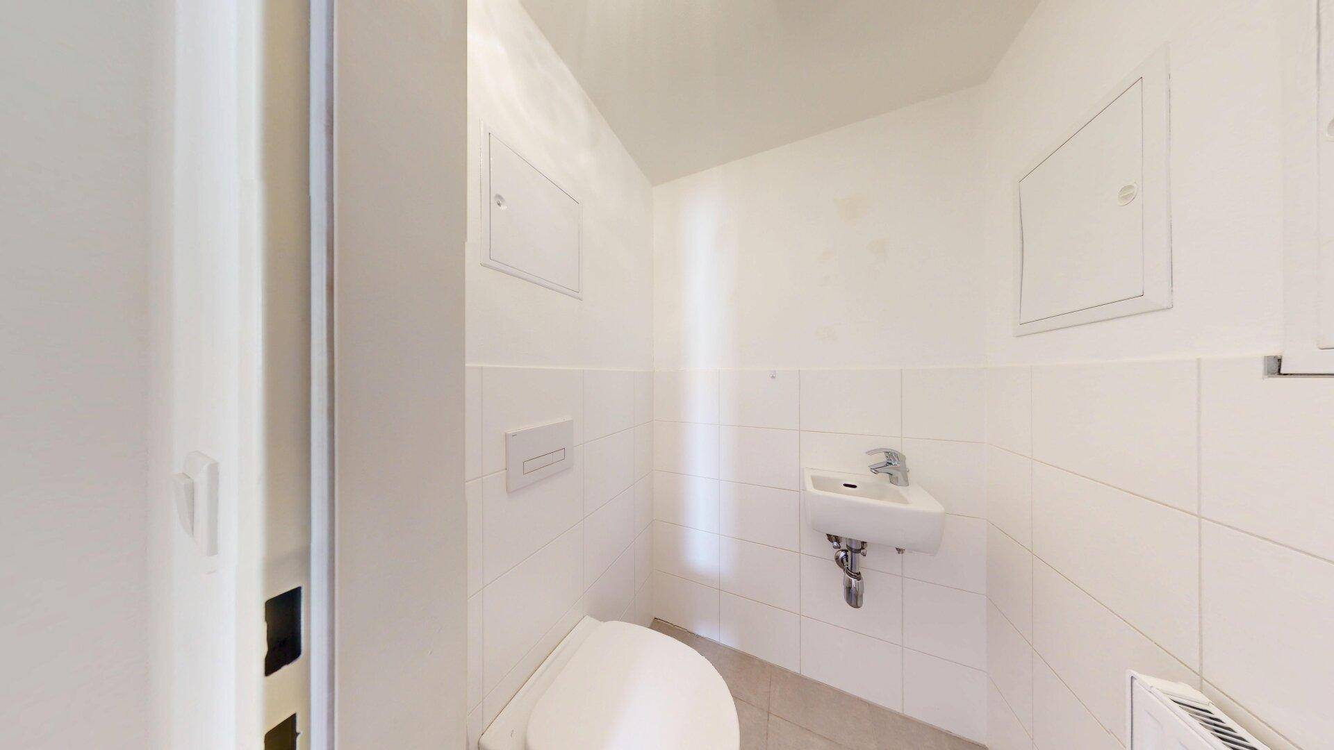 Kleines Gäste-WC mit Wand-WC und Handwaschbecken.