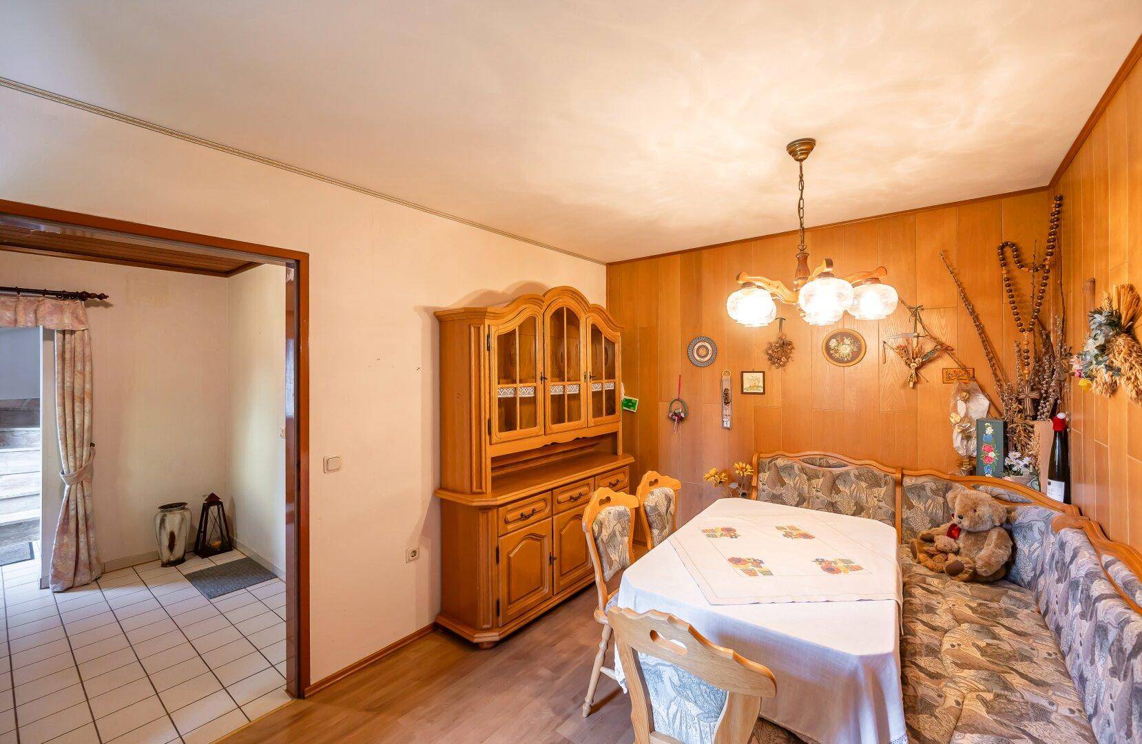 Gemütliches Esszimmer mit Holztäfelung, traditionellen Möbeln und einem Esstisch mit Eckbank.