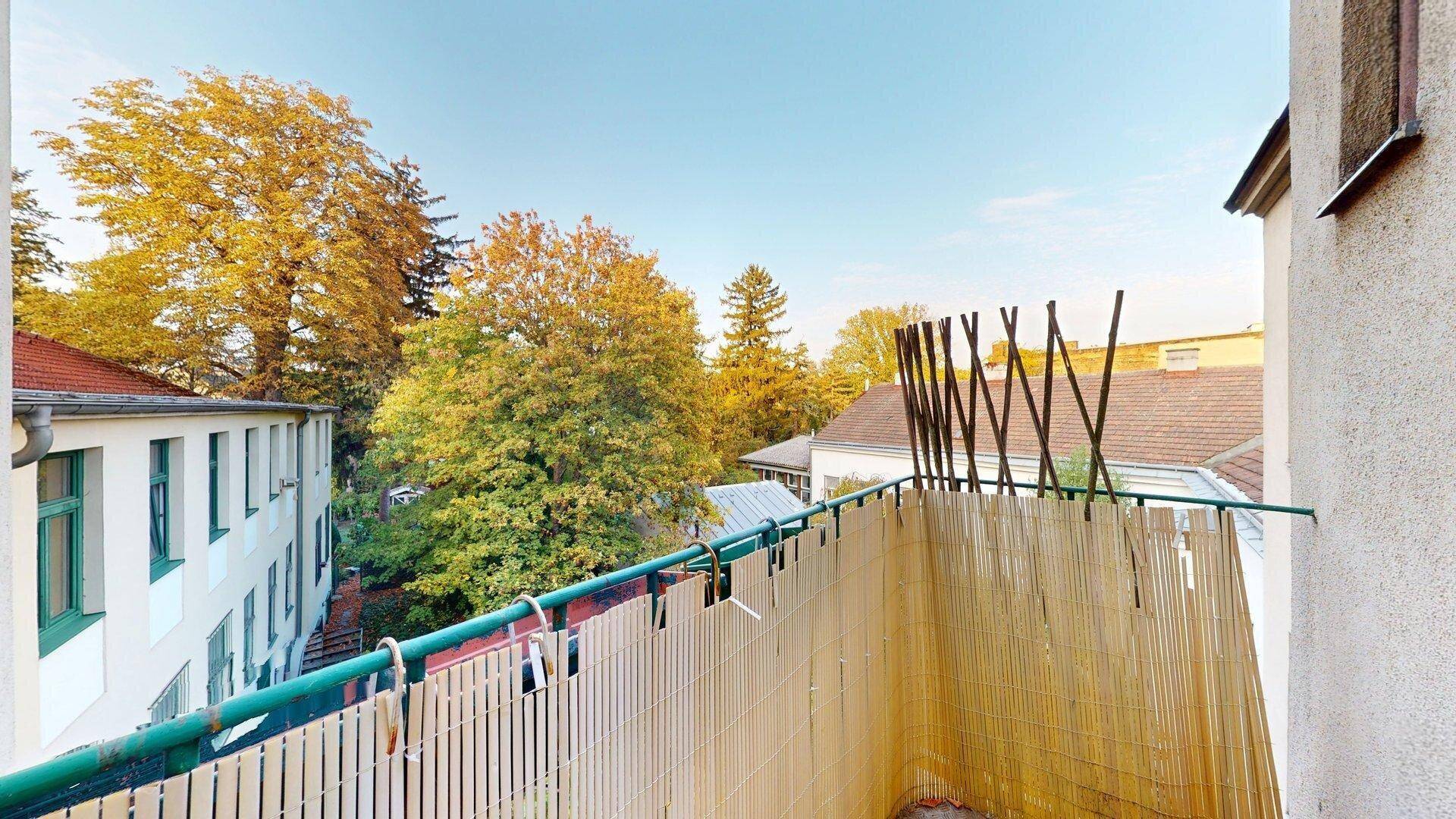 Kleiner Balkon mit Sichtschutz und Blick ins Grüne, ideal für entspannte Stunden im Freien.