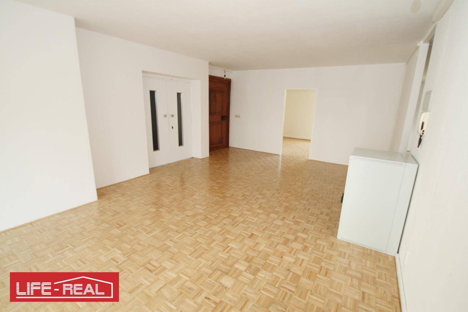 Geräumiger Eingangsbereich mit Parkettboden und Zugang zu verschiedenen Zimmern der Wohnung, hell und einladend.