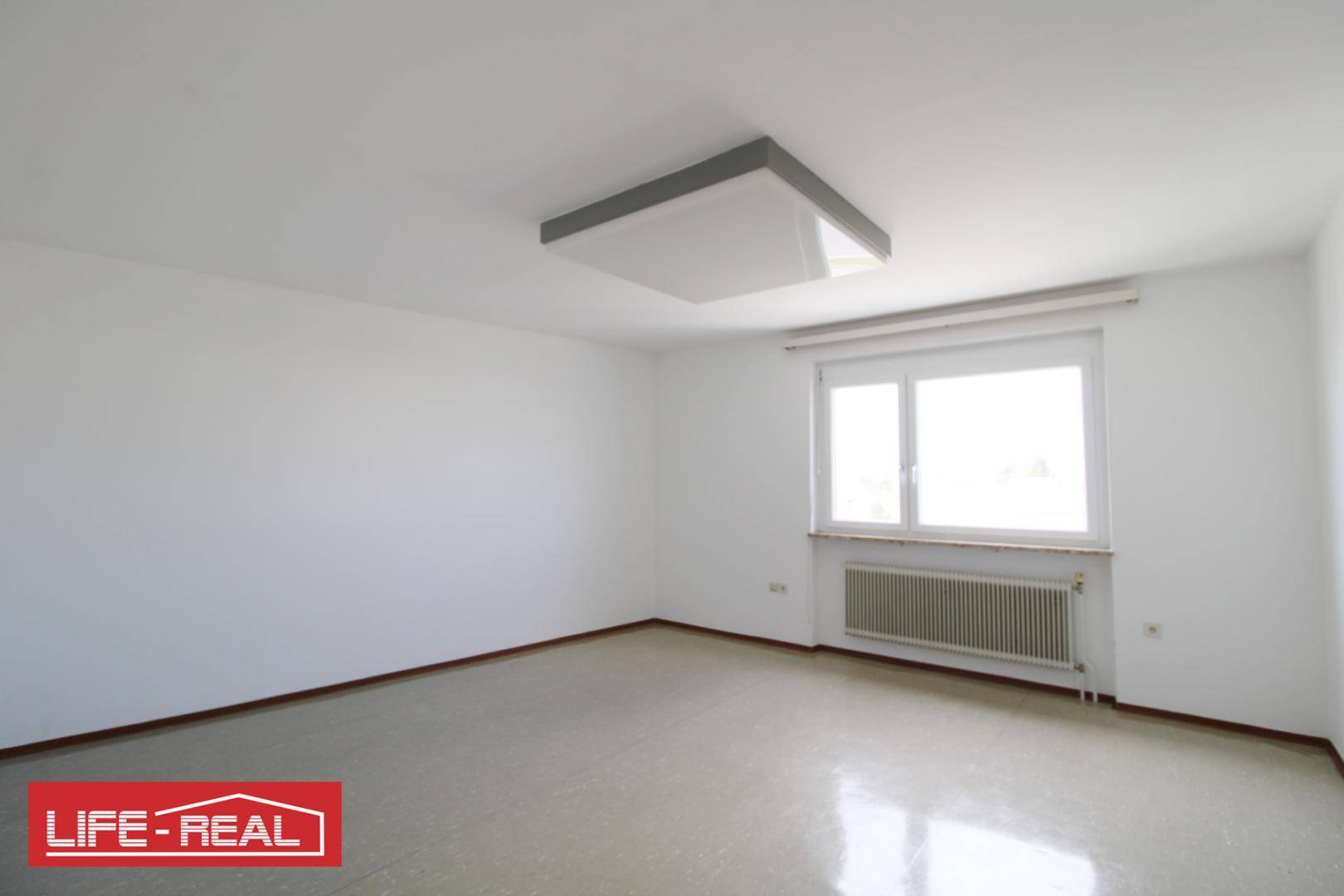 Sauberer, leerer Raum mit Fenster und Heizung, bietet viel Potenzial für verschiedene Nutzungen.