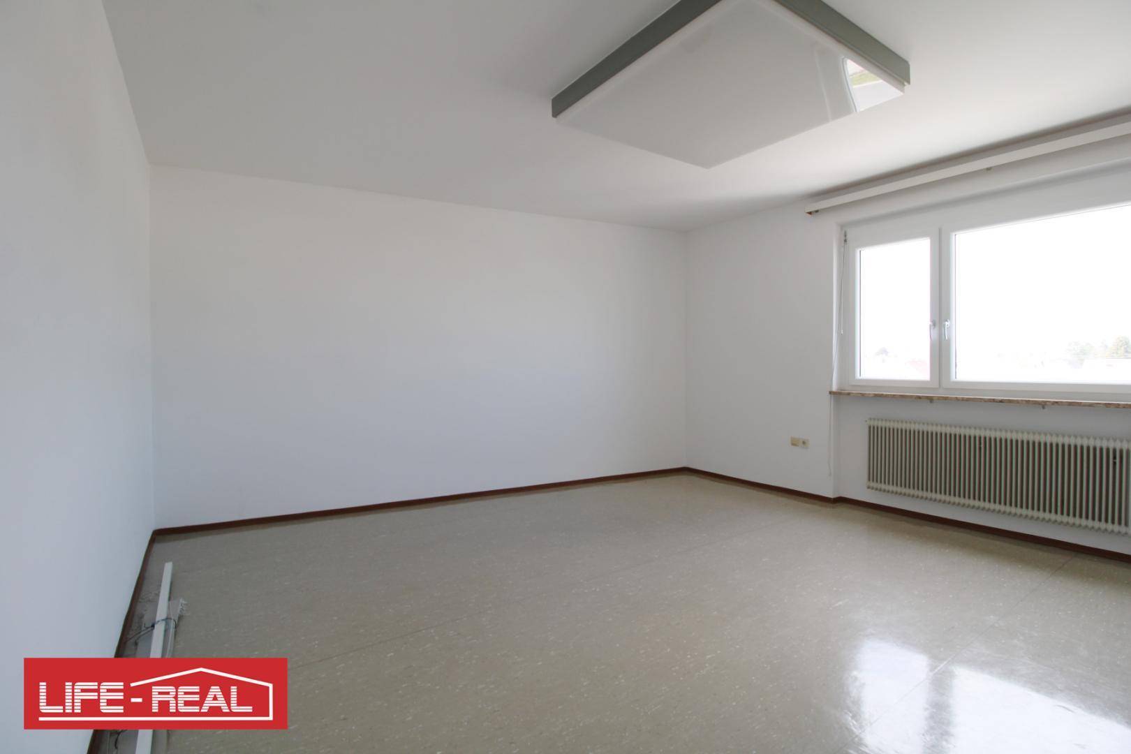 Unmöblierter Raum mit hellem Fenster und Heizkörper, bereit für die nächste Einrichtung oder Nutzung.