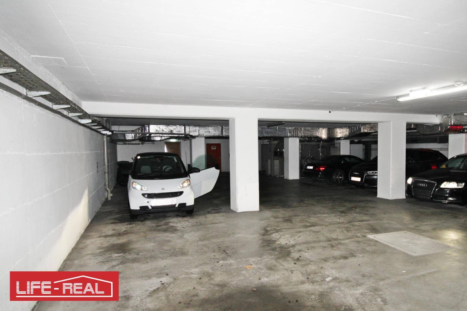 Geräumige Tiefgarage mit mehreren Stellplätzen und tragenden Säulen.