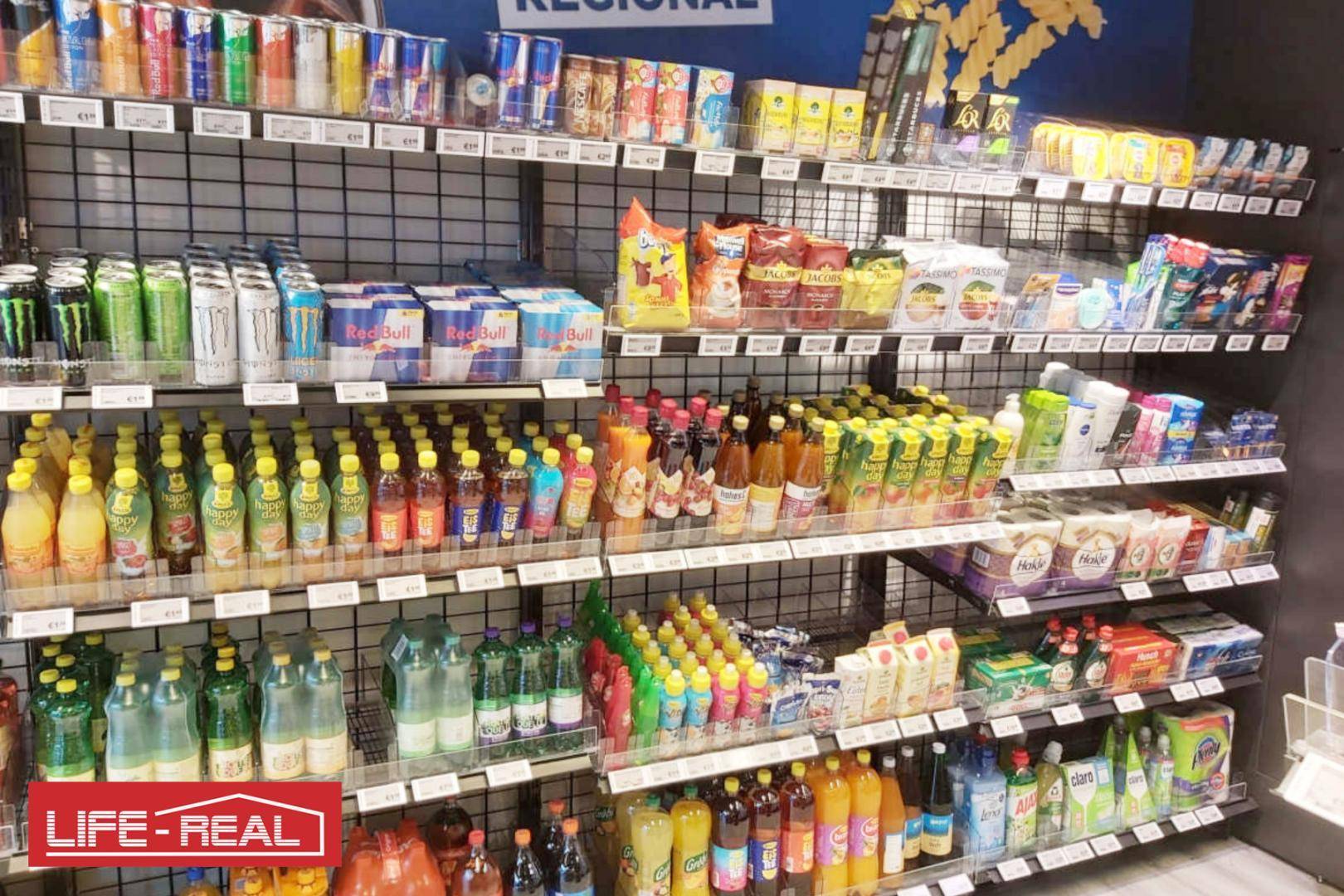 Gut sortierte Regale eines Ladenlokals mit einer Vielfalt an Getränken, Snacks und Drogerieartikeln.