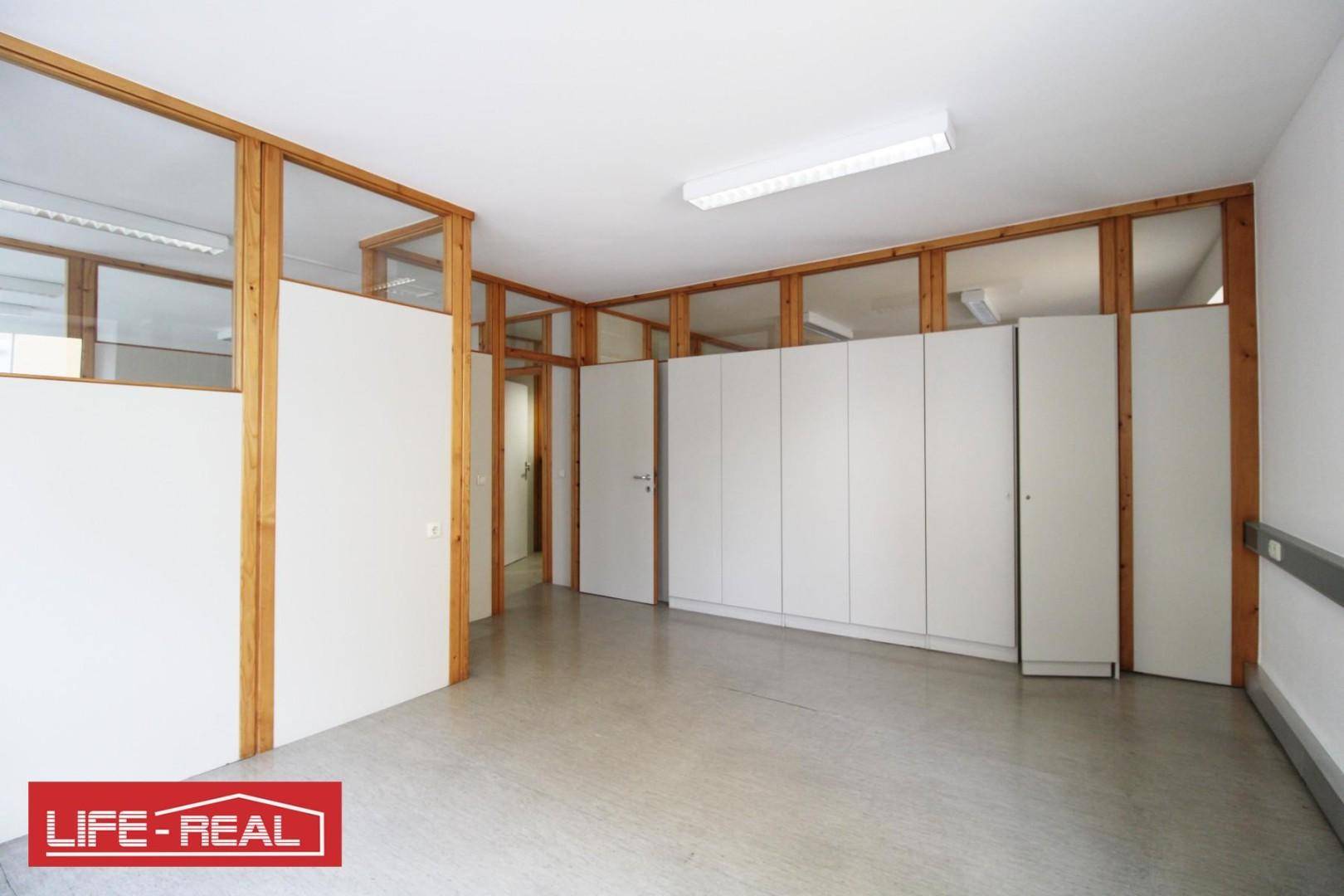 Geräumiger Büroraum mit Holz-Glas-Trennwänden und integrierten Schränken, ideal für flexible Arbeitsbereiche.