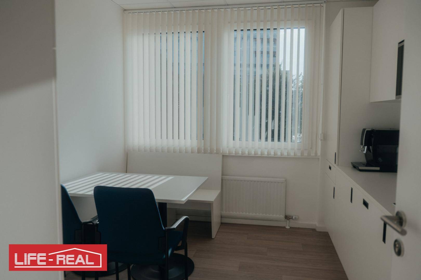 Kleiner Pausenraum mit Tisch, Sitzbank und Kaffeemaschine, ideal für kurze Erholung.