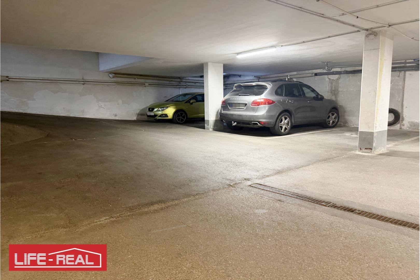 Tiefgarage mit geparkten Autos und Betonstützen, bietet sichere Stellplätze.