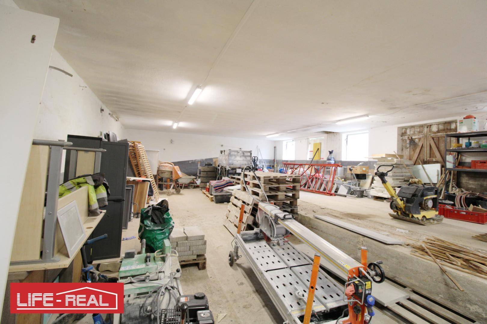 Großer Lagerraum mit Baustellenmaterialien und Geräten, bereit für die Fertigstellung oder Nutzung.