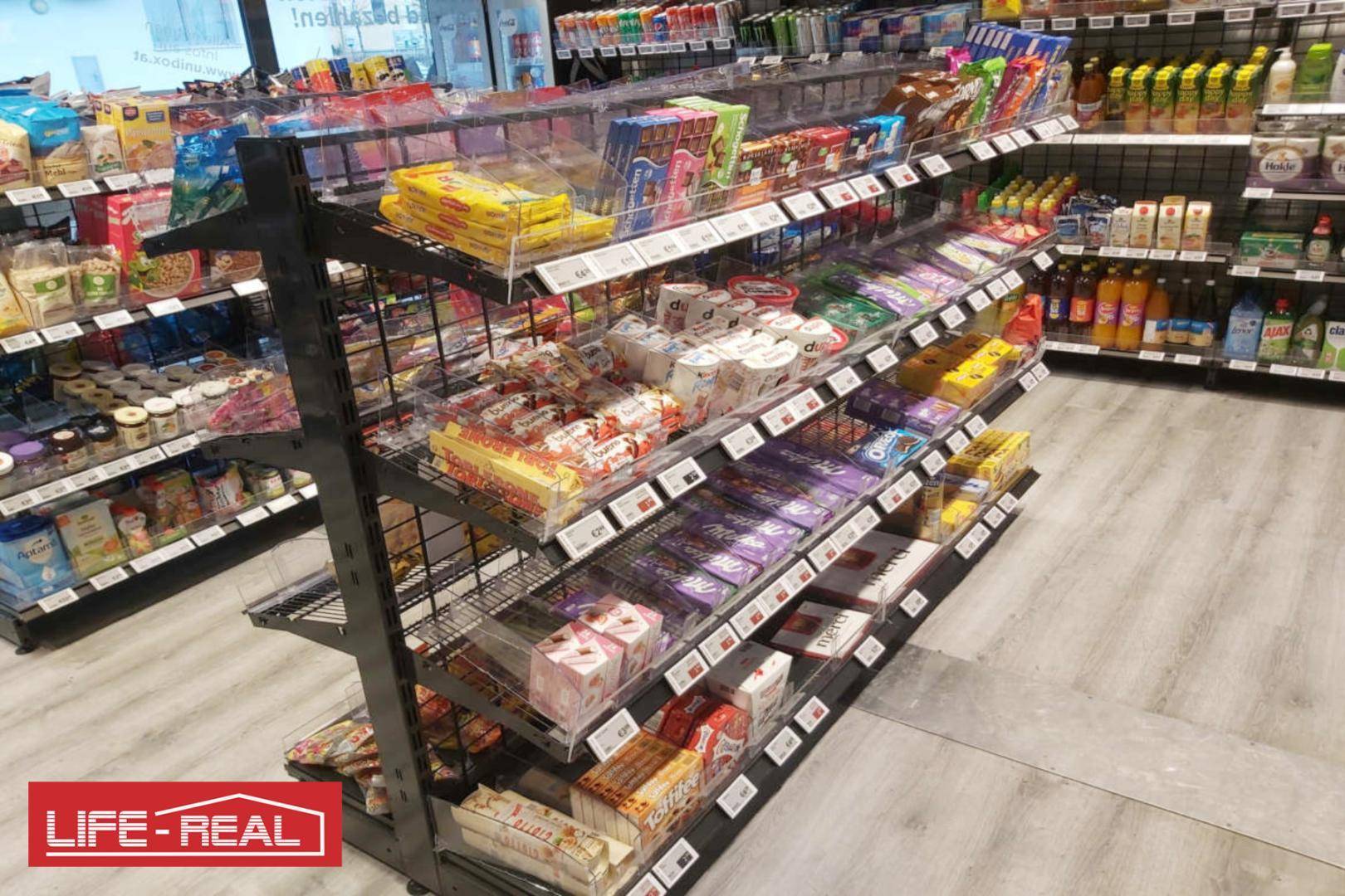 Innenansicht eines Ladens mit Regalen, die eine Vielzahl von Schokoladen und Süßwaren präsentieren.
