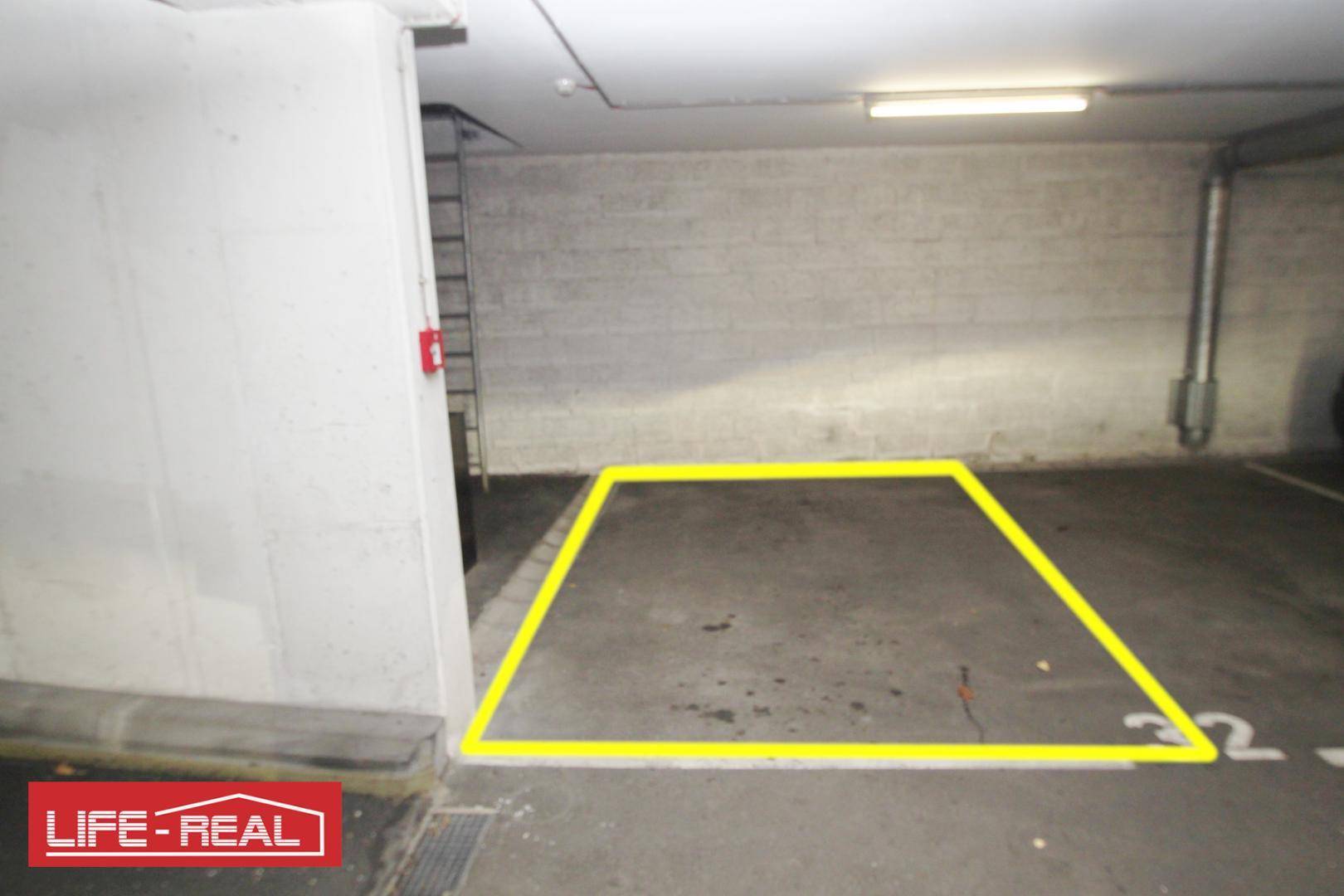 Geräumiger Tiefgaragenstellplatz mit klarer gelber Markierung für ein Fahrzeug.