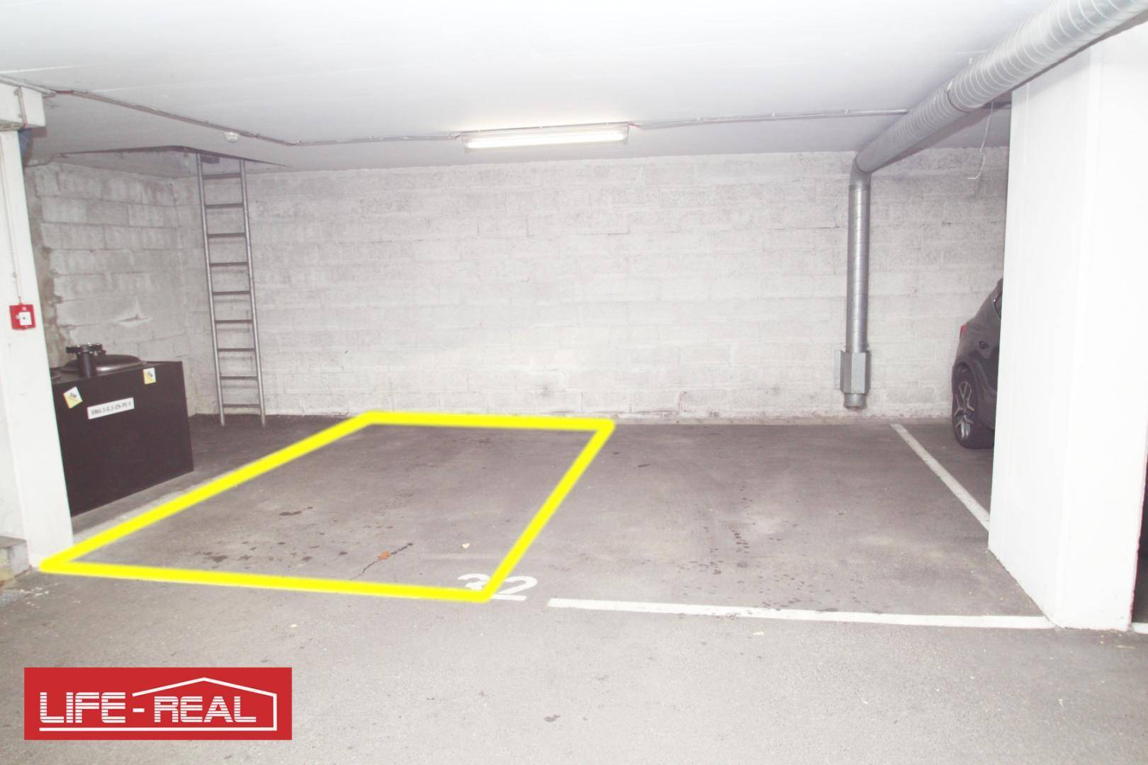 Tiefgaragenstellplatz mit gelber Markierung in einem modernen Parkhaus.