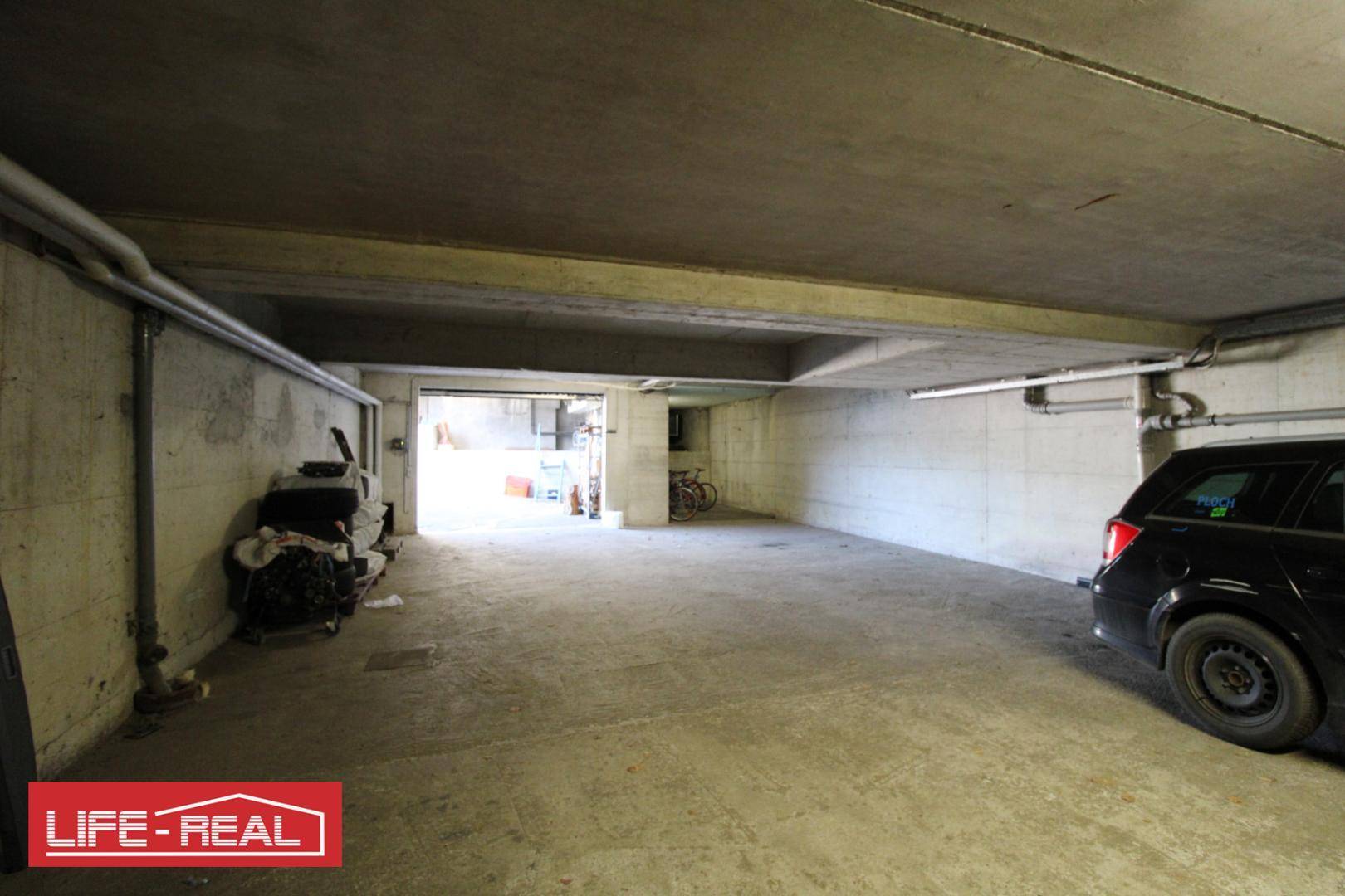Geräumige Tiefgarage mit Betonwänden und -decke, bietet Platz für mehrere Fahrzeuge.
