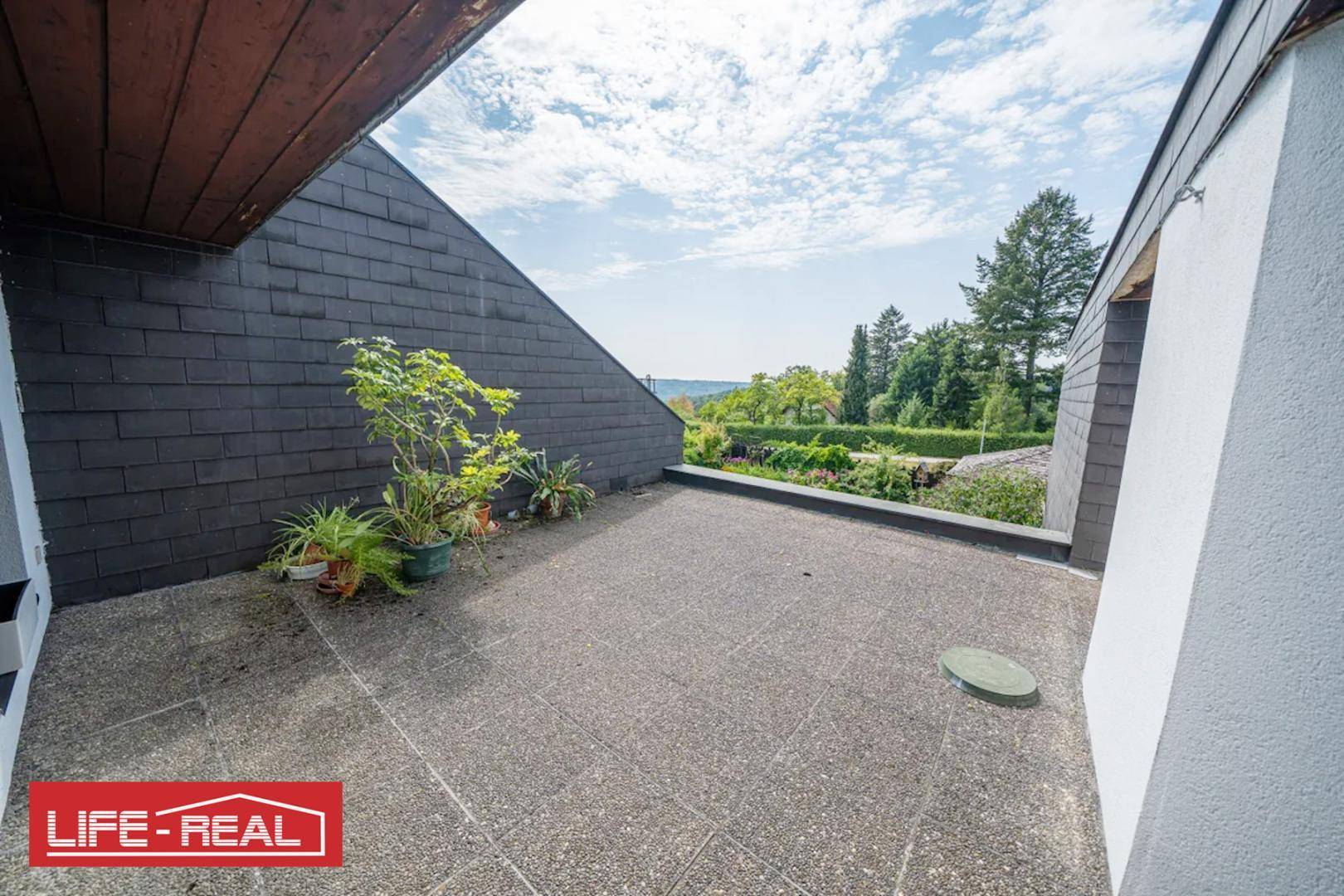 Geräumige Dachterrasse mit weitem Blick ins Grüne, ideal für sonnige Stunden im Freien.