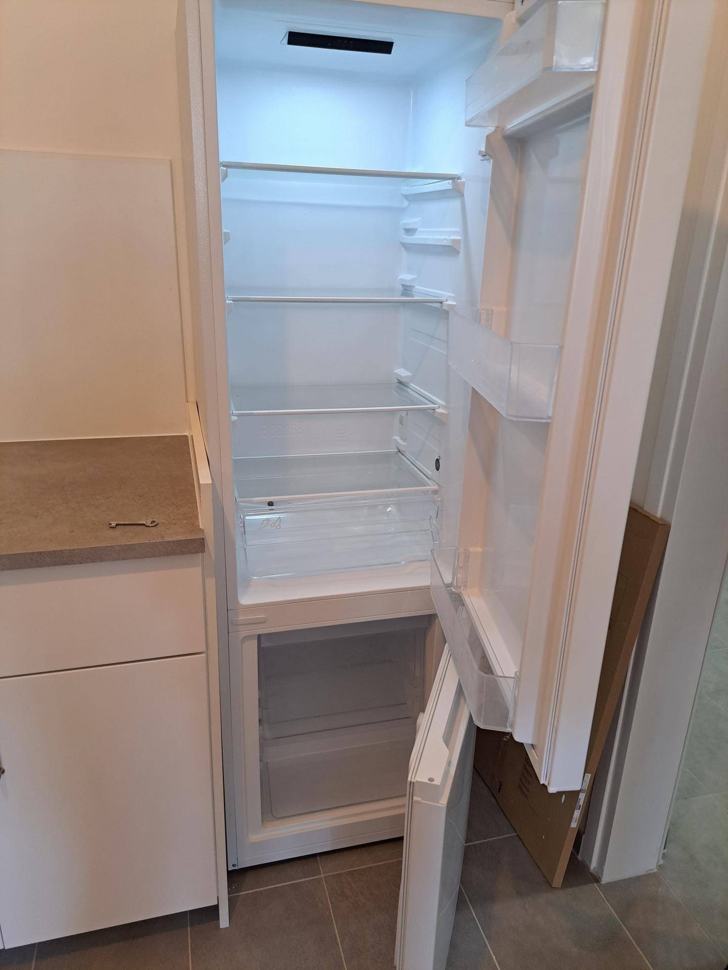 Offener Kühlschrank mit Gefrierfach, integriert in die neue Küchenzeile.