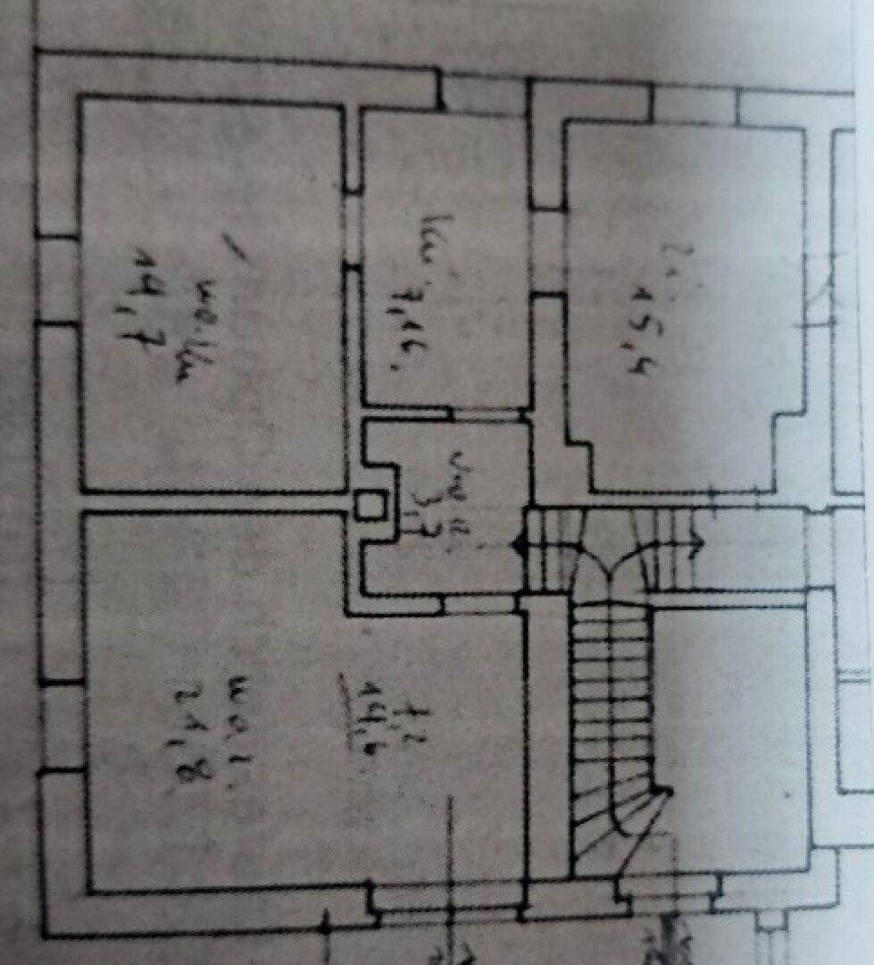 Grundriss mit mehreren Räumen und Treppenhaus.