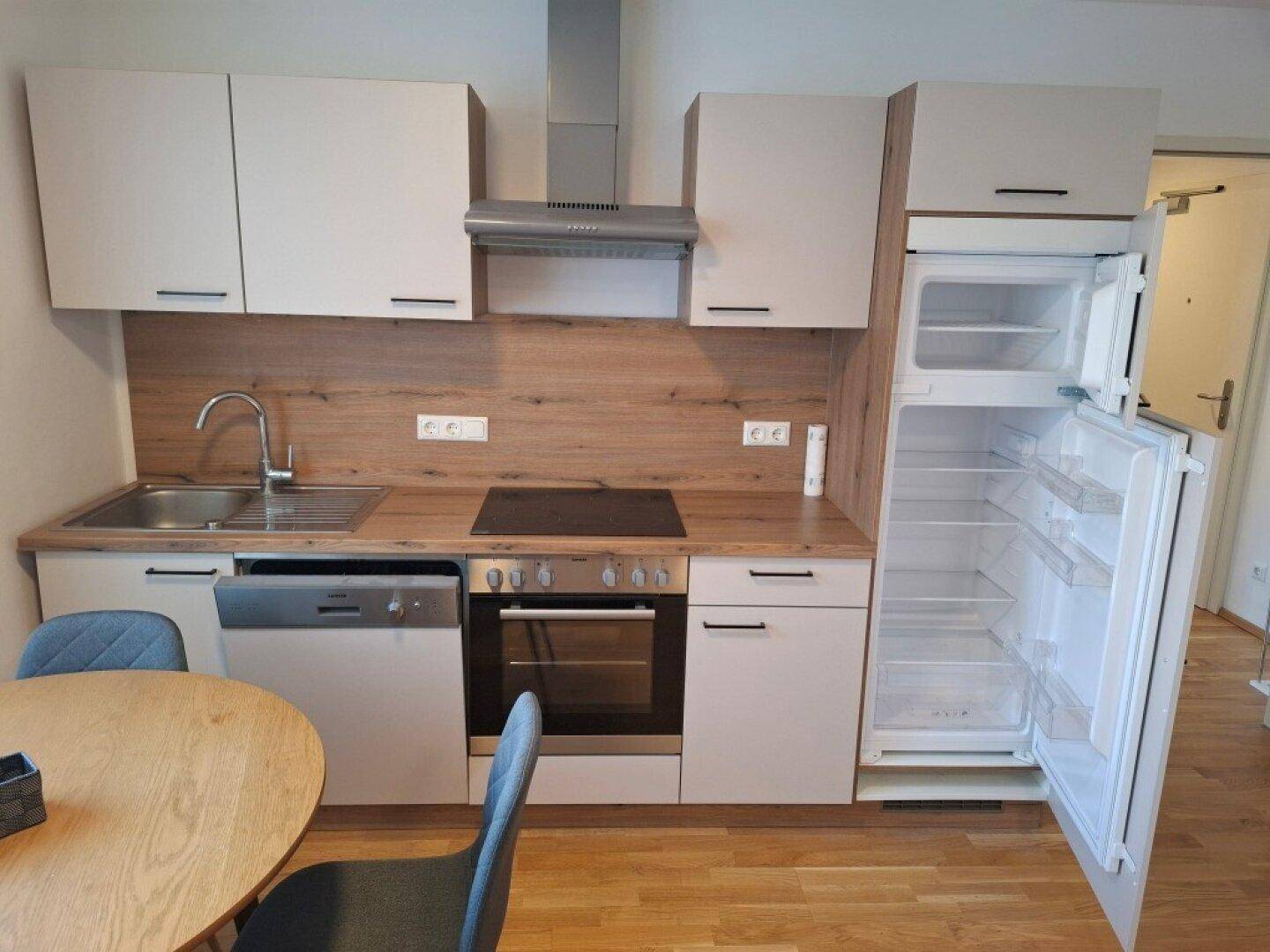 Detailansicht der modernen Einbauküche mit integriertem Geschirrspüler, Backofen und Kühlschrank.