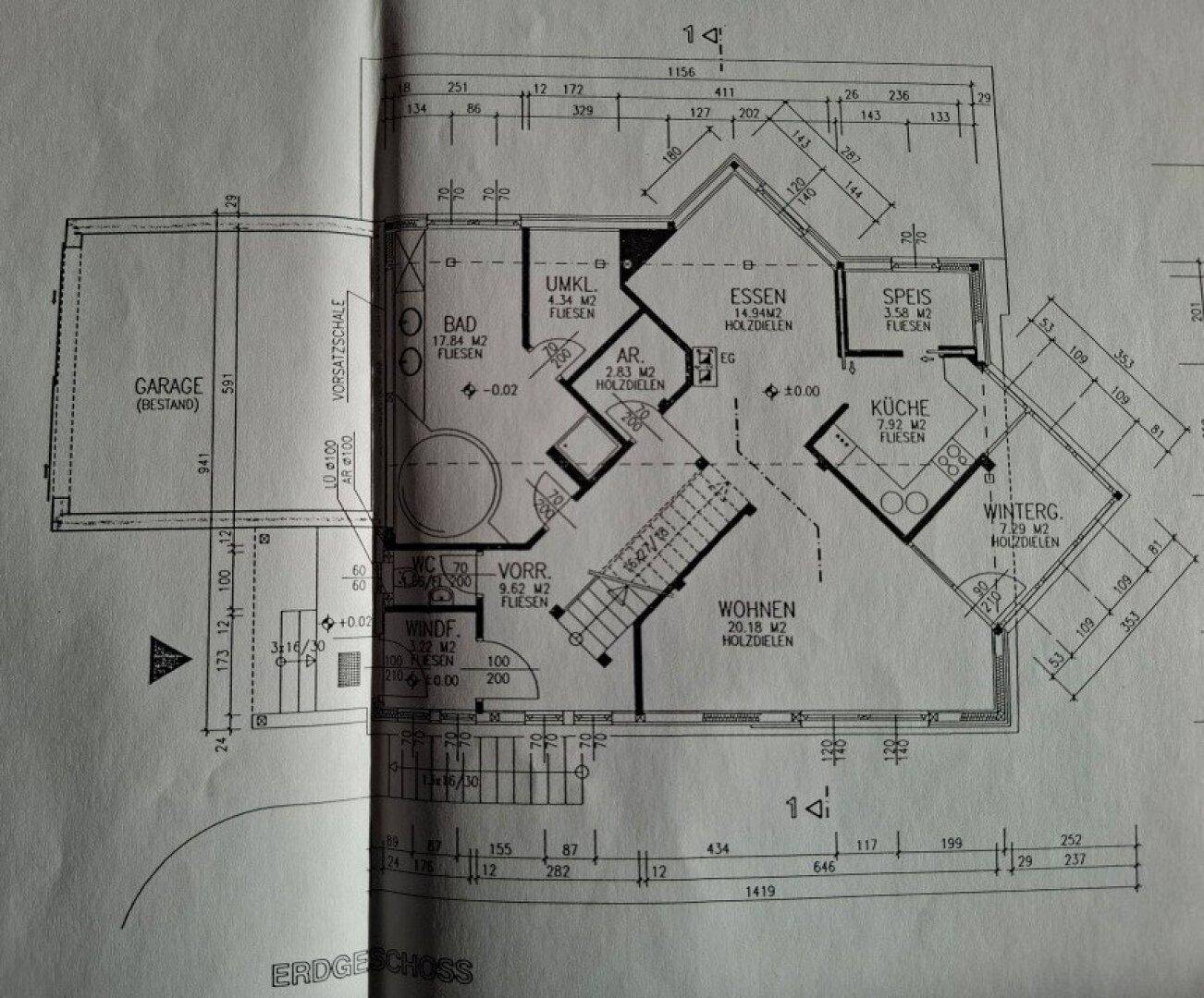 Grundriss des Erdgeschosses mit Wohnzimmer, Küche, Bad und Wintergarten.