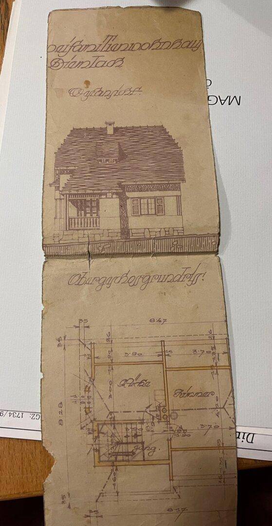 Detailansicht eines alten Bauplans mit Gebäudezeichnung und Grundriss.