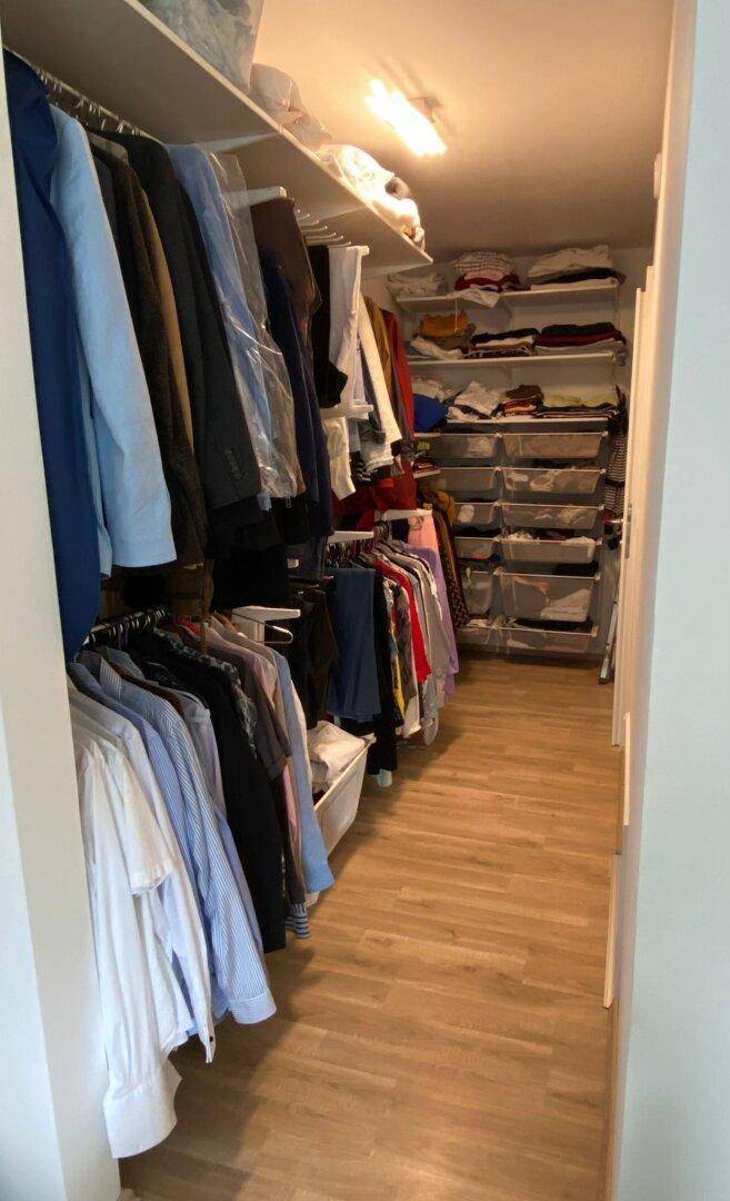 Geräumiger begehbarer Kleiderschrank mit vielen Regalen und Hängemöglichkeiten für Kleidung.