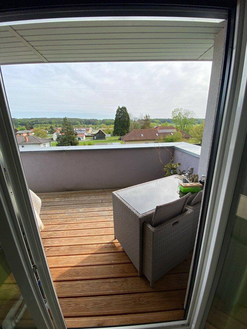 Balkon mit Holzboden und Sitzgelegenheiten, bietet einen weiten Blick über die umliegende Landschaft.