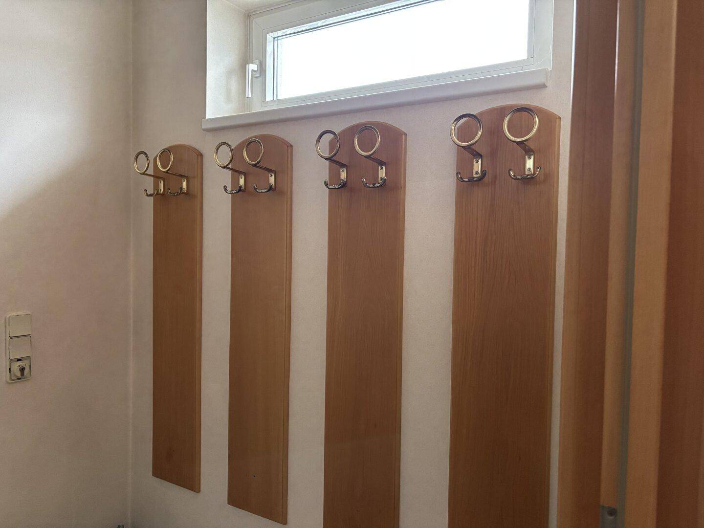 Eingangsbereich oder Flur mit hölzernen Garderobenleisten und einem Fenster.