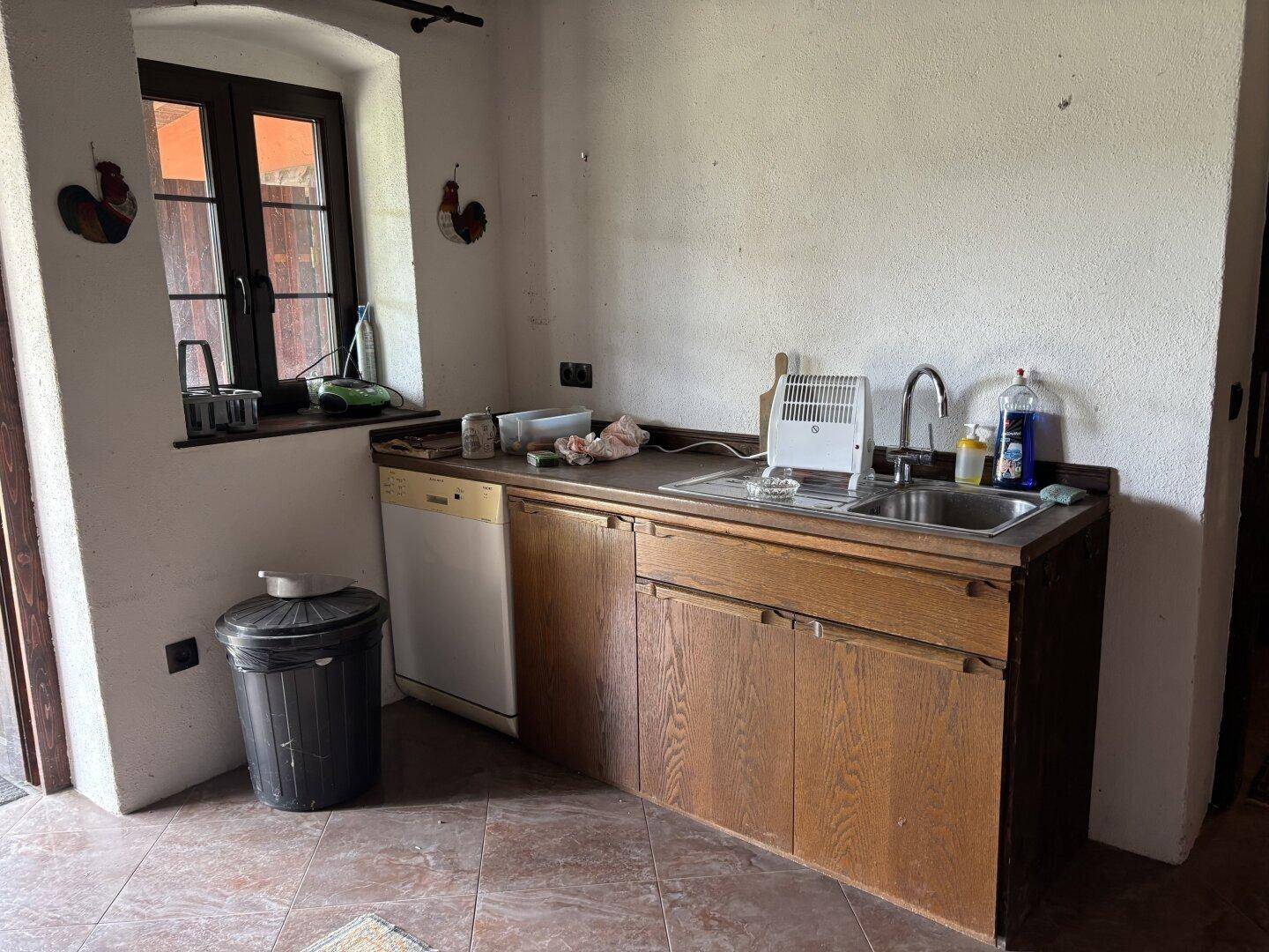 Küchenzeile mit Spüle, Unterschränken und Geschirrspüler, mit Fenster.