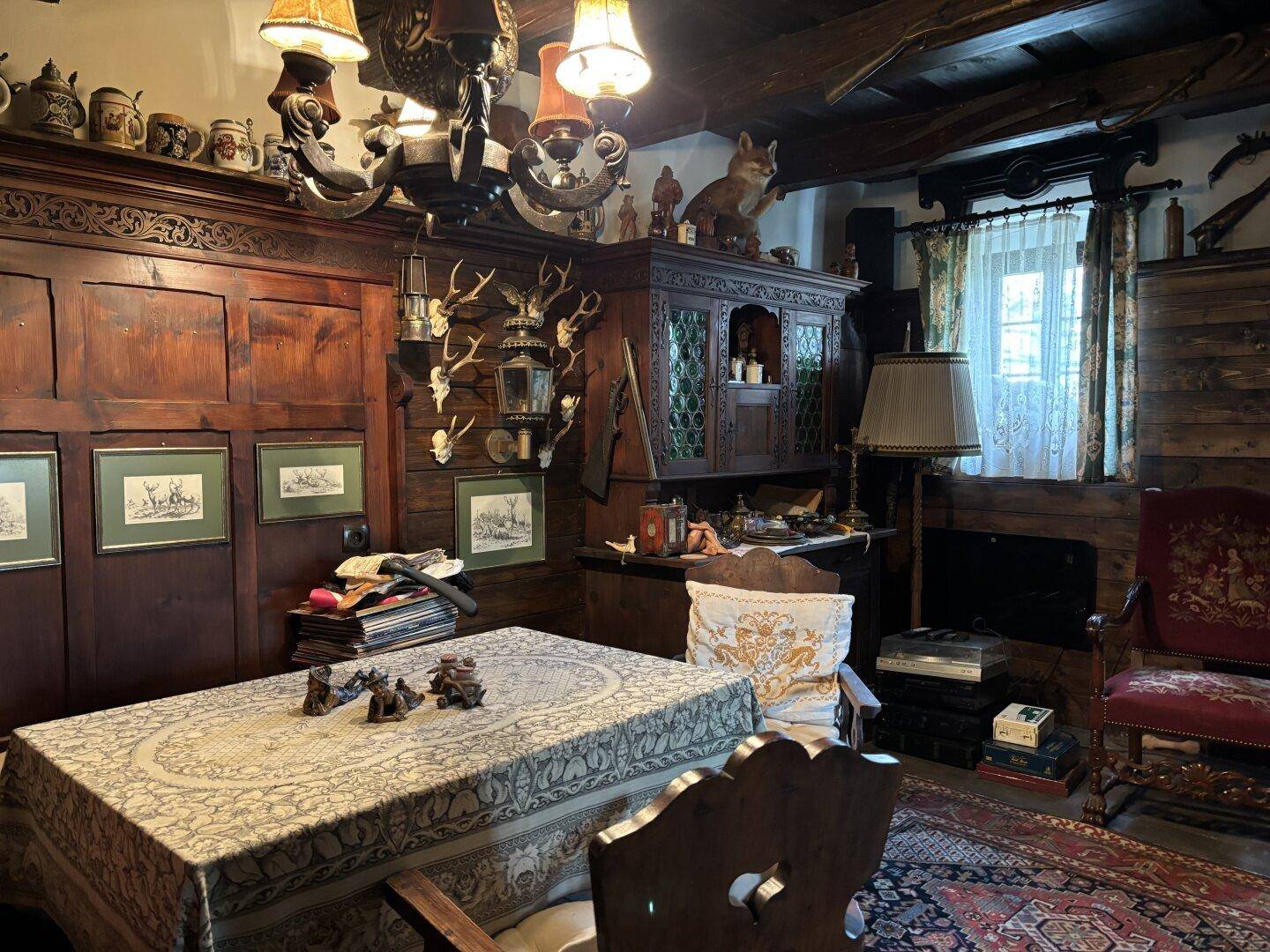 Traditioneller Essbereich mit dunklen Holzmöbeln, einem großen Esstisch und Jagdtrophäen.