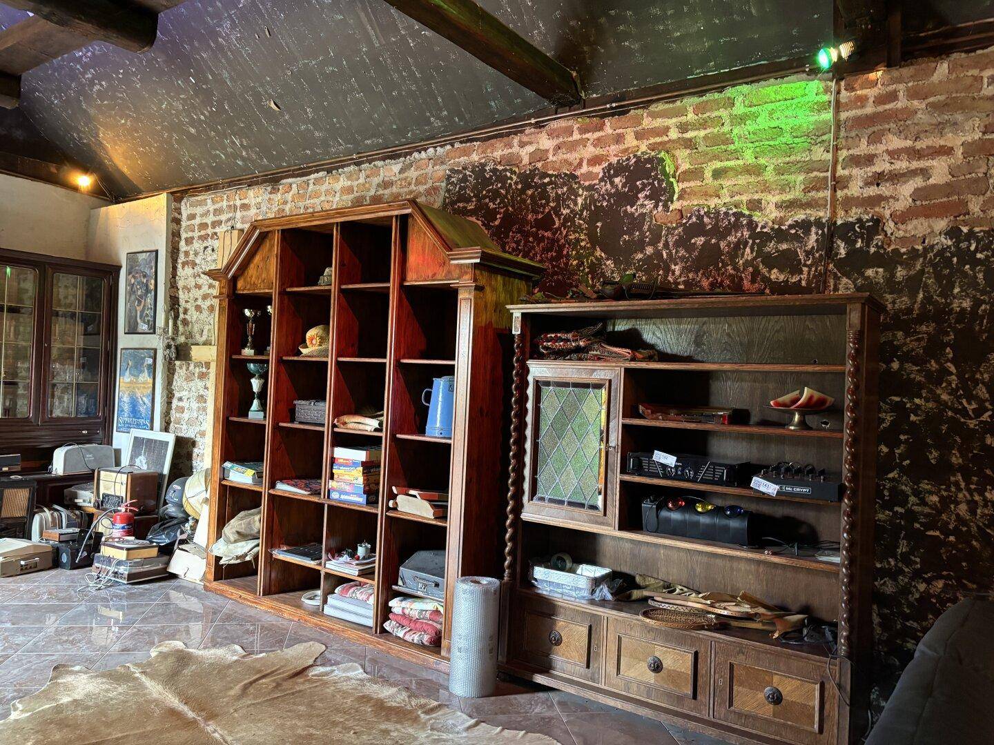 Detailansicht des Wohnbereichs mit großen Holzregalen und rustikalen Dekorationselementen.