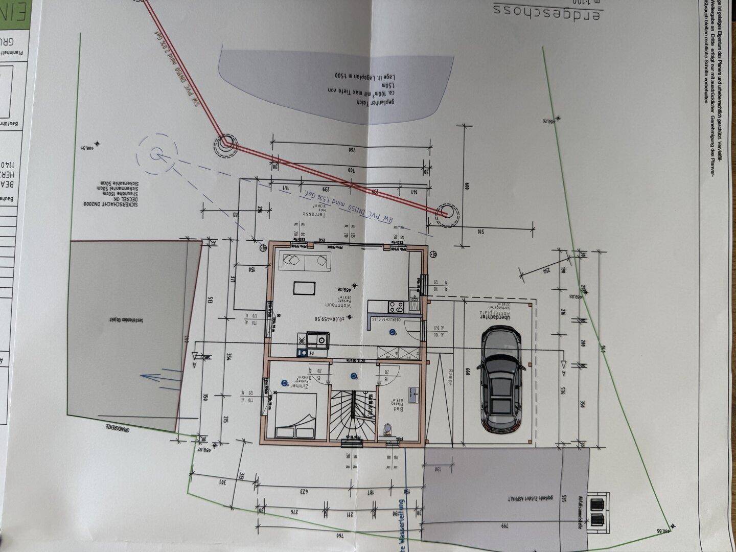 Grundriss des Erdgeschosses mit Wohnbereich, Küche, Schlafzimmer und Carport.