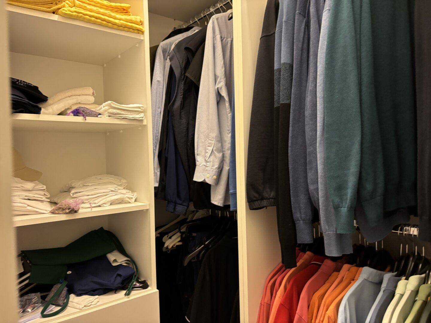 Gut organisierter begehbarer Kleiderschrank mit Regalen und Kleiderstangen für viel Stauraum.