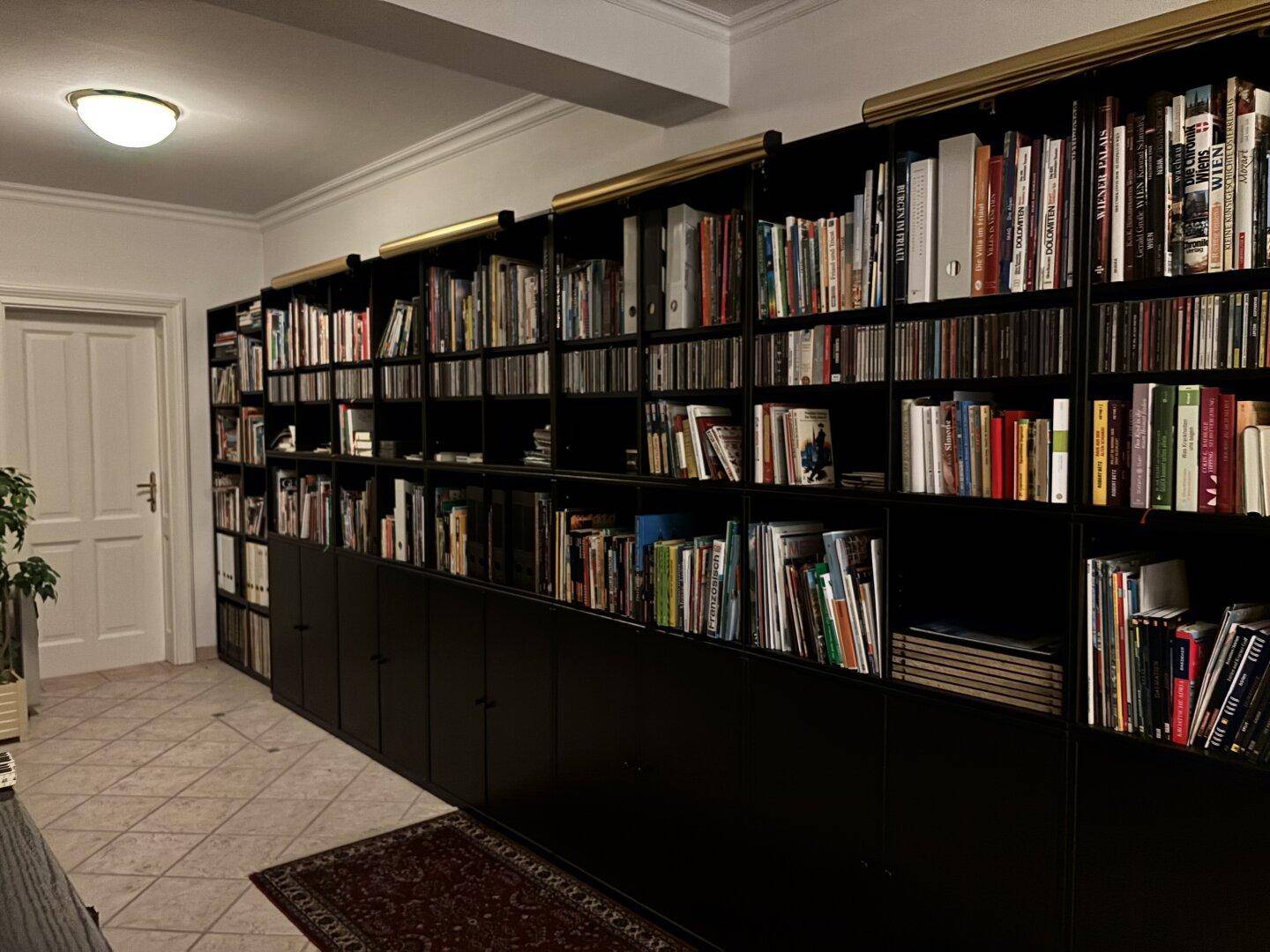 Langer Flur mit raumhohen Bücherregalen, der als private Bibliothek dient.