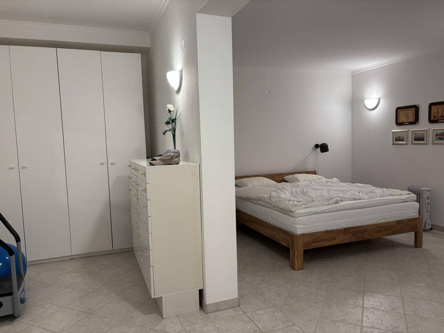 Geräumiges Schlafzimmer mit Doppelbett und großen weißen Kleiderschränken.