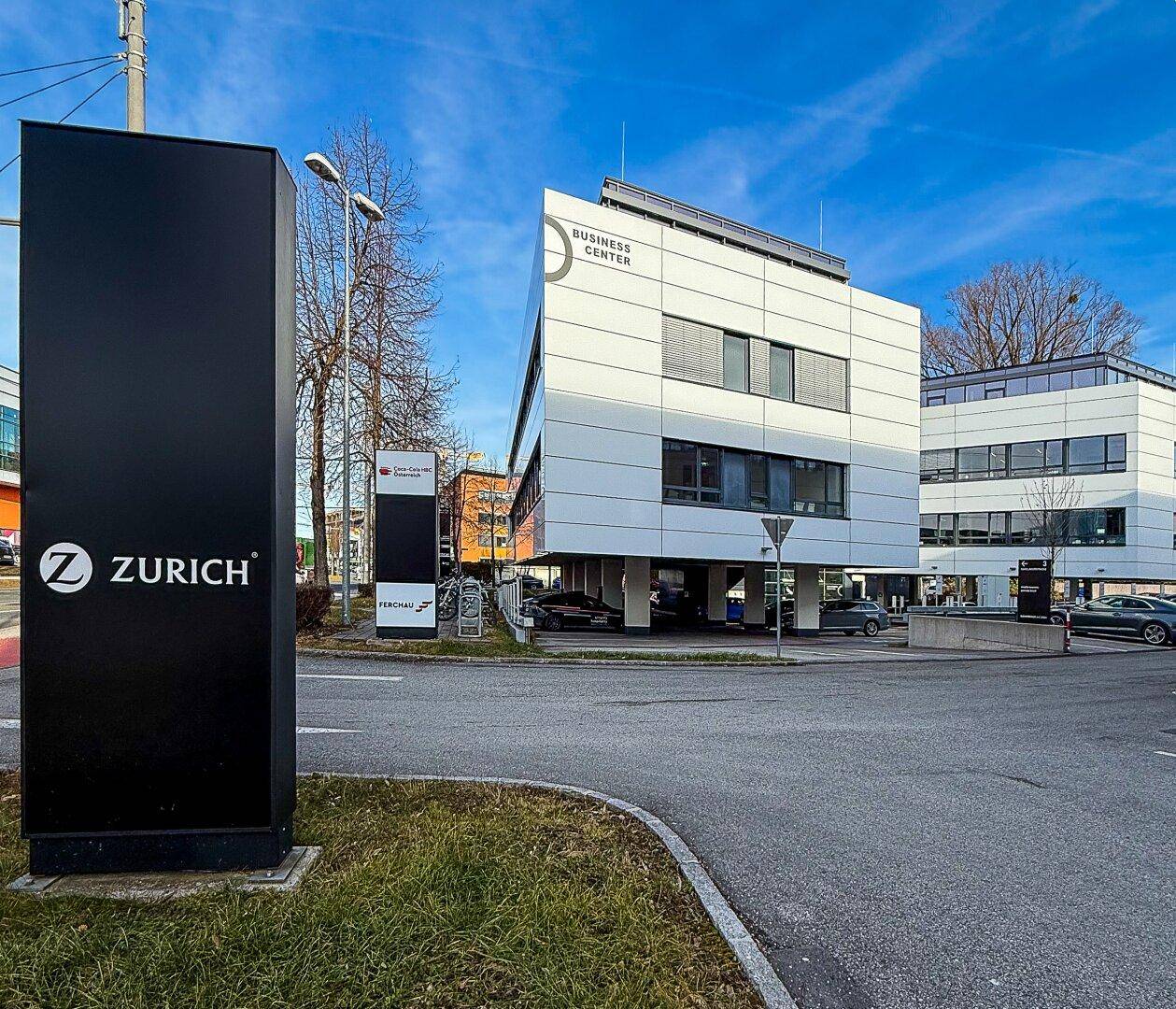 Modernes Geschäftsgebäude mit markanter Architektur und Beschilderung in einer städtischen Umgebung.