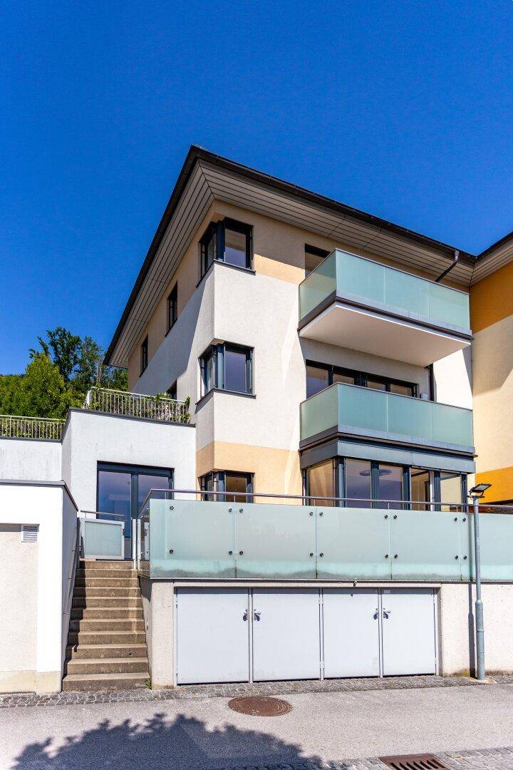 Ansicht der modernen Wohnanlage mit Garagen, Treppen und Balkonen.