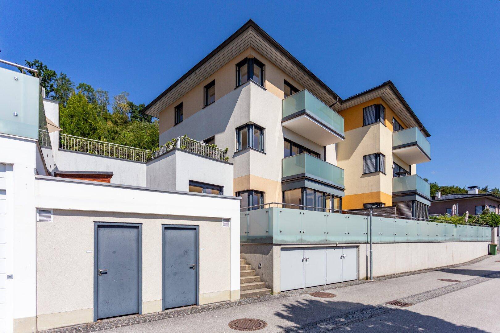 Ansicht der modernen Wohnanlage mit Garagenzugang und Balkonen.