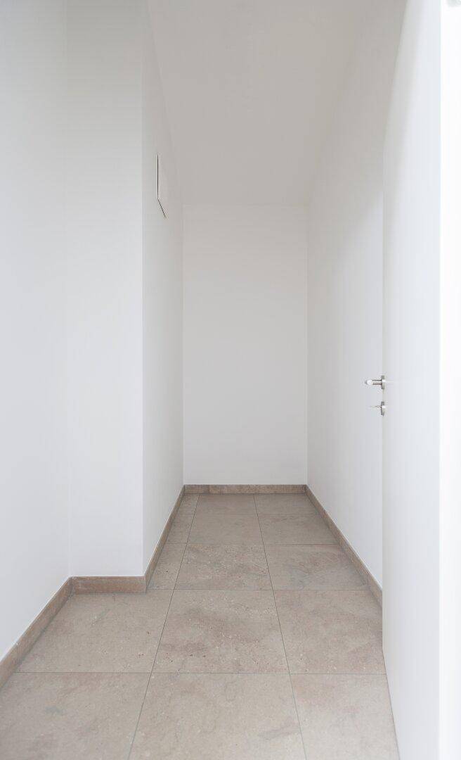 Praktischer Abstellraum mit Fliesenboden und weißen Wänden für zusätzlichen Stauraum.