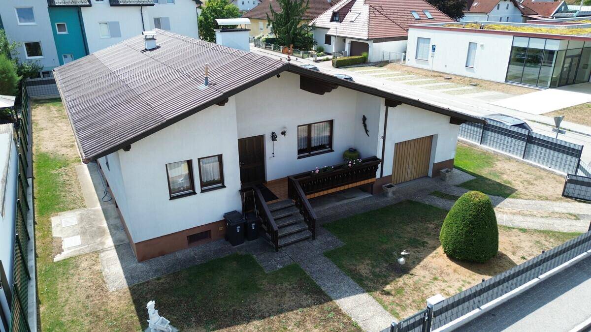 Ansicht des Einfamilienhauses mit Vorgarten, integrierter Garage und Zugang zum Haupteingang.
