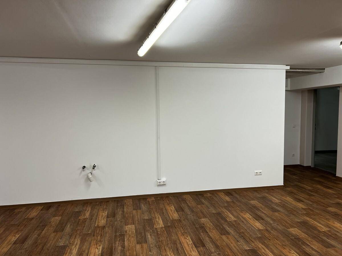 Wandbereich mit elektrischen Anschlüssen und Rohren, die auf eine mögliche Küchenzeile hindeuten.