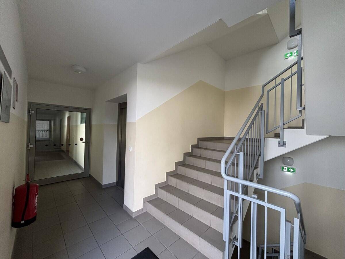 Treppenhaus mit Fliesenboden, Geländer und Brandschutzvorrichtungen.
