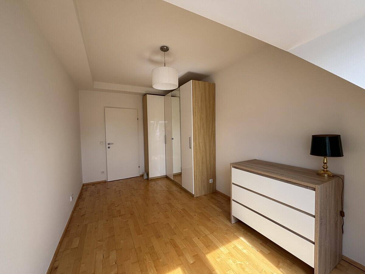 Geräumiges Schlafzimmer mit Dachschrägen, Holzboden und Kleiderschrank.