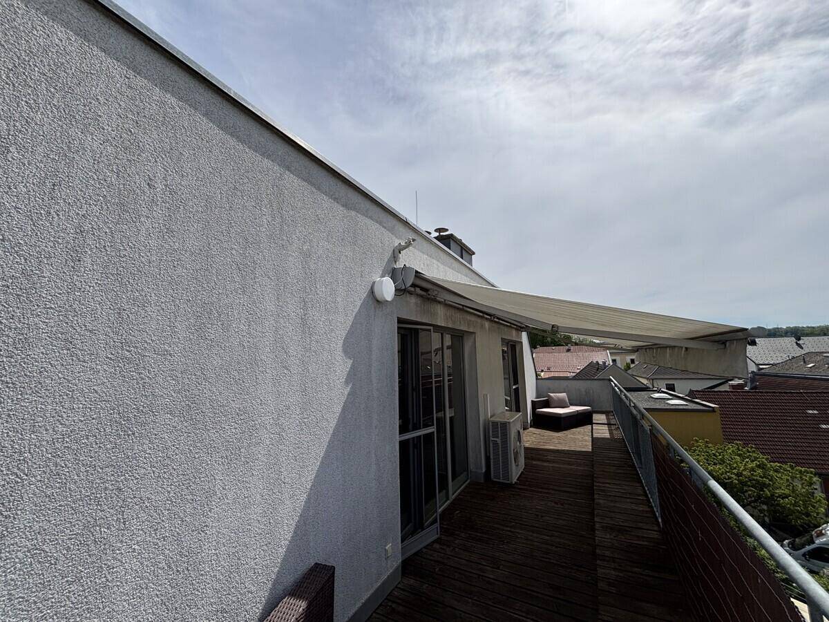 Große Dachterrasse mit Markise und Blick auf die Umgebung.